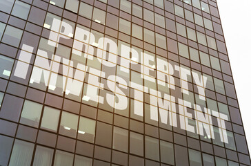 On the glass surface of the business center there is an inscription - property investment