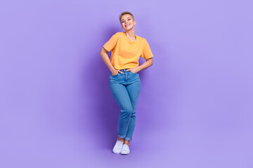 Full size photo of good mood optimistic girl dressed sneakers denim pants holds arms in pockets...