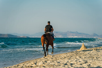  mężczyzna na koniu nad plaży - obrazy, fototapety, plakaty