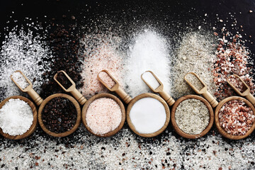 Colorful mix of salt varieties: sea and black, table and pink, himalayan and celtic. Food ingredients on dark background - obrazy, fototapety, plakaty
