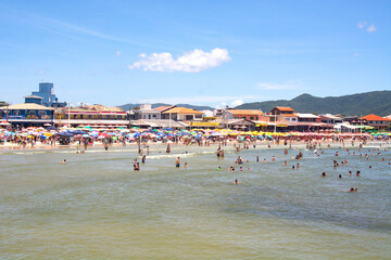 Obraz premium FLORIANOPOLIS, BRAZIL - JANUARY 21, 2023 : crowded beach Praia da Barra da Lagoa in Florianopolis, Brazil