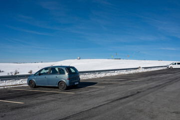 Obraz na płótnie Canvas Parking for 2 cars on the Wasserkuppe with a view of the dome in winter with lots of snow