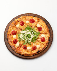 Pizza with cherry tomatoes and mozzarella on wooden board. Pizza is decorated with herbs and sauce. Italian Cuisine. Isolate on white background. View from above. Copy space. 