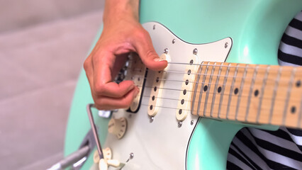 Woman's hand plays an electric guitar