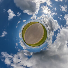 tiny planet in blue overcast sky with beautiful clouds with transformation of spherical panorama...