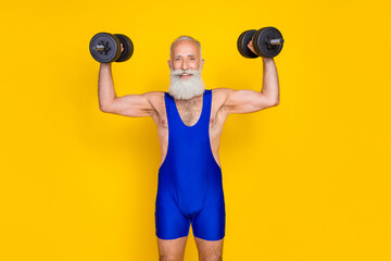 Photo of cheerful sportive aged person hands hold lifting dumbbells isolated on yellow color background