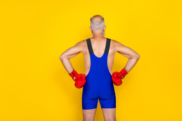 Photo of back sportive old aged man grandfather grey hair touch waist kickboxer professional training powerful isolated on yellow color background