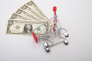 american one dollar banknotes in a shopping cart on white background