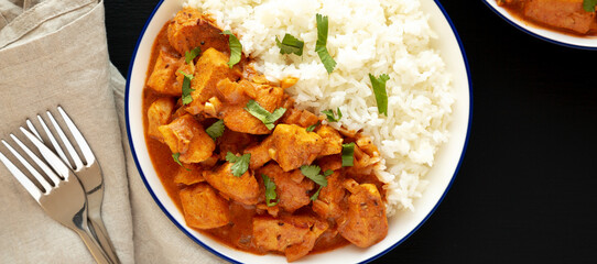 Homemade Easy Indian Butter Chicken with Rice on a Plate on a black background, top view. Flat lay, overhead, from above.