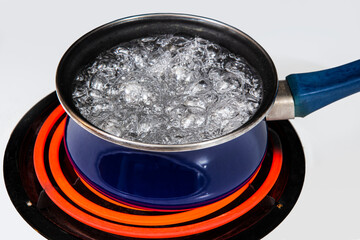 Water In Full Rolling Boil Inside Blue Pan On Stove Top