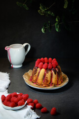 home made marble cake with sugar glaze and raspberries on top, dark grey background 