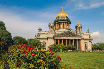 Panoramic view on Saint Isaac's Cathedral. Isaakievskiy Sobor with green lawn and red roses in summer, St. Petersburg, Russia. High quality photo