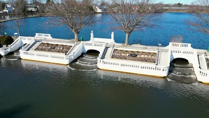Drone hovering above the waterfalls at Argyle Lake park in Babylon Village New York with the lake in the background.