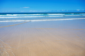 Beautiful Newquay beach with blue sea, stone cliffs and white sand in Cornwall, south west England, selective focus