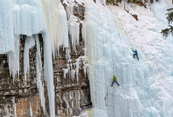 Unrecognizable ice climbers on frozen Upper Falls in Johnston Canyon in Banff National Park, Alberta, Canada