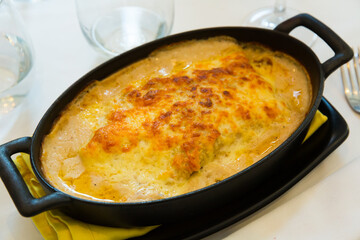 Traditional Spanish meat lasagna with parmesan cheese served in iron pan