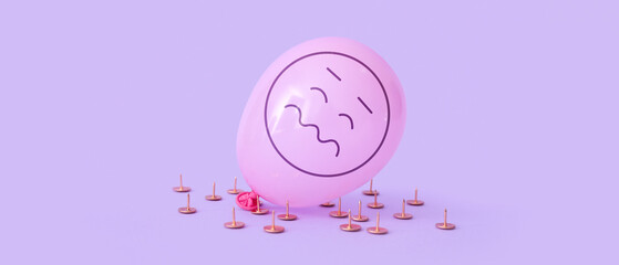 Paper pins and air balloon with drawn stressed emoticon on lilac background