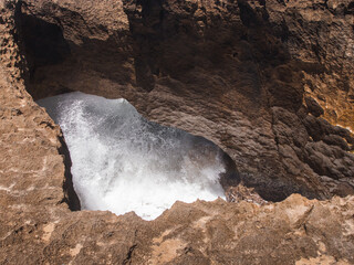 Pozo de jacinto puerto rico big ground hole in the coast with water splash into the rock