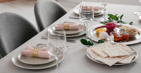 Passover Seder plate with traditional food on served table in dining room