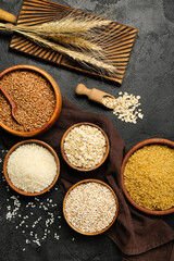 Composition with bowls of different cereals on dark background