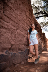 mujer latina en antigua casa de adobe en dia soleado