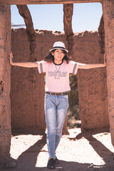 Naklejka na ściany i meble mujer adolescente con sombrero en antigua casa de adobe, Catamarca Argentina