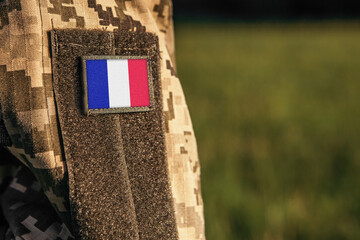 Close up millitary woman or man shoulder arm sleeve with France flag patch. France troops army,...
