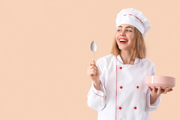 Female chef with spoon and bowl on beige background