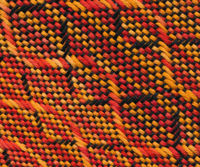 Close-up handwoven wavy pattern in black, orange and red.