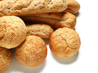 Loaves of delicious baguette and buns with sesame seeds isolated on white background