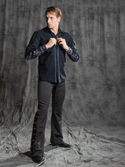 attractive man in an elegant suit, shirt with embroidery. Touching the cuff, buttoning the button....