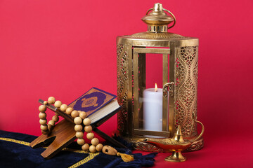 Muslim lantern with Koran and prayer beads for Ramadan on red background