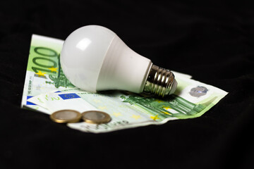 Concept of saving light and money. electric light bulb on money and coins Finance and saving...