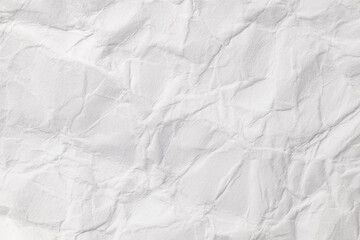 Crumpled white paper with corrugations and fractures, uneven surface, background texture, close-up