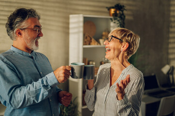 Senior couple drinking morning coffee together at home