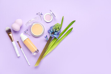 Composition with cosmetics, makeup accessories and hyacinth flower on lilac background