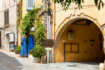 A small clothing store boutique near a tunnel passageway in the medieval old town center of Grimaud, France, in the Provence Cote d'Azur region.