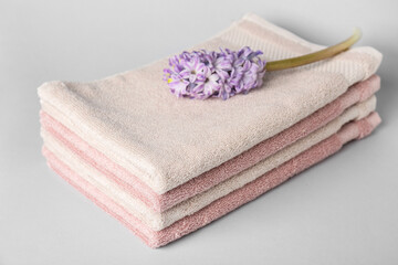 Fototapeta na wymiar Stack of soft towels and hyacinth flower on white background