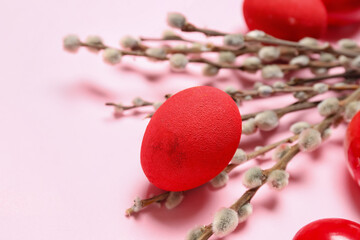 Painted Easter eggs and willow branches on pink background, closeup