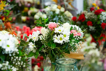 Naklejka premium Bouquet of flowers on background of other flowers in vase in a flower shop