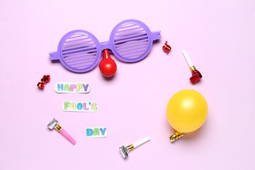 Frame made of text HAPPY FOOL'S DAY, funny disguise, balloon and party blowers on pink background