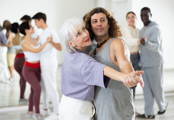 Fototapeta premium Caucasian man and mature woman rehearsing latin paired dance moves