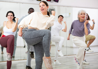 Fototapeta premium Active people of different nationalities learn sports dancing at a group class in a dance studio