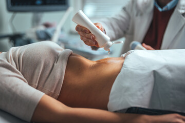 Gynecologist doctor does ultrasound, sonogram procedure to a pregnant woman. Doctor makes the...