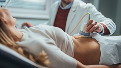 Doctor makes the patient women abdominal ultrasound. Ultrasound Scanner in the hands of a doctor. Diagnostics. Sonography. Close-up Of Doctor  - obrazy, fototapety, plakaty