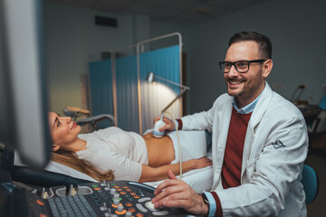 Ultrasound scanner device in hand of professional doctor examining his patient. Expecting pregnancy. Doctor in white lab coat and sterile gloves examining woman with ultrasound scanner