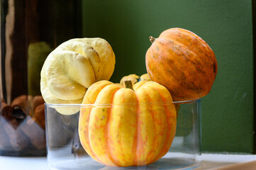 Three pumpkins in a glass container indoor