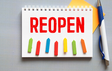 Yellow note paper with word reopening on cork board background with copy space.