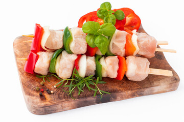 Raw turkey skewers with vegetables,peppers,onions white background.Skewers with pieces of raw meat,red, and green pepper.Top view.Uncooked mixed meat skewer with peppers.Turkey Skewers breast fillet.