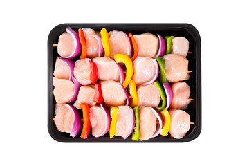 raw chicken fillet skewers with vegetables in a tray on a white background.Skewers with pieces of raw meat, red, yellow and green pepper. Close-up.Top view.